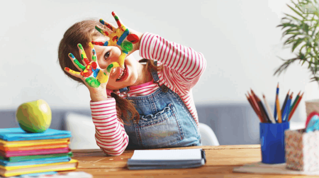 little girl proudly exhibit her finger full of paint
